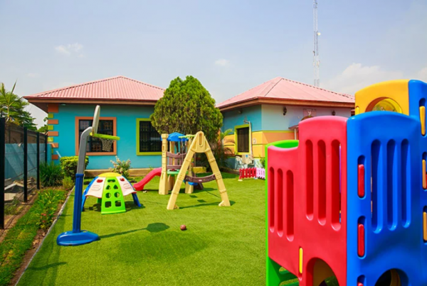 Taman dengan area bermain anak yang dilengkapi dengan rumput sintetis